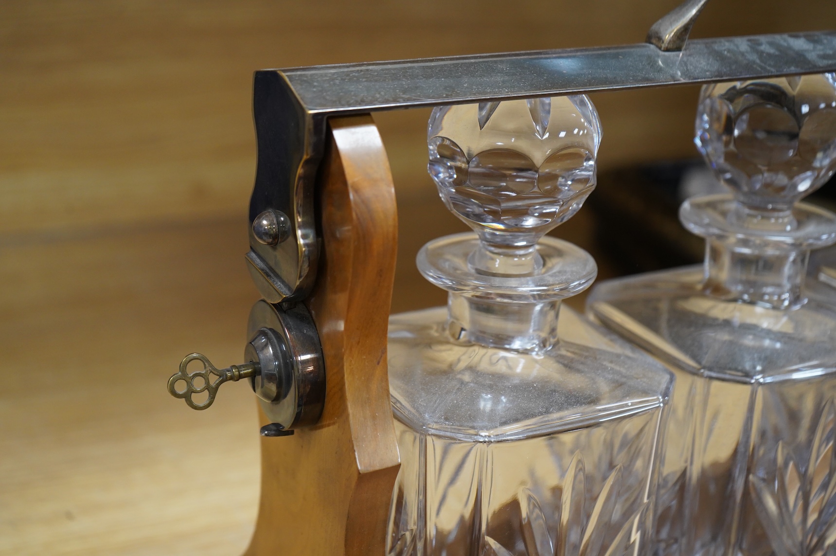 A walnut three-decanter tantalus, 41cm